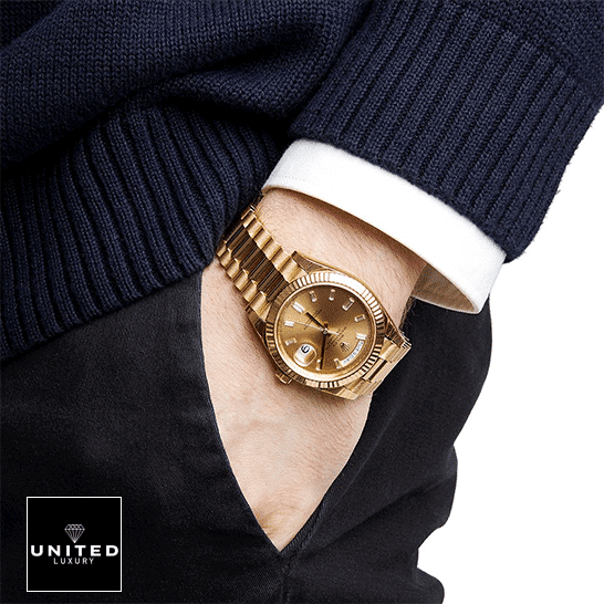 the gold Rolex Day Date watch on the man's arm
